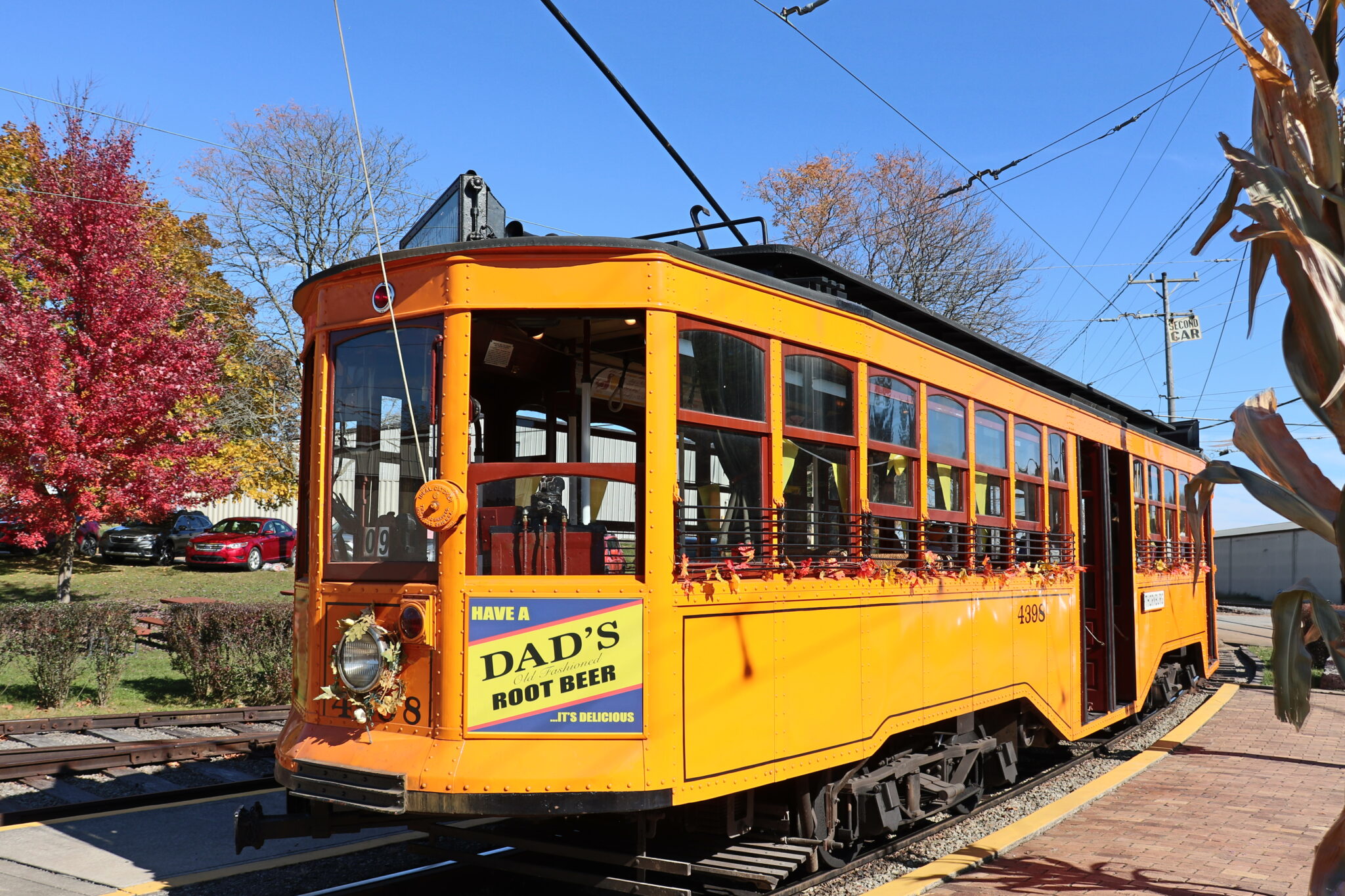 4398 trolley with trees with fall colors in background