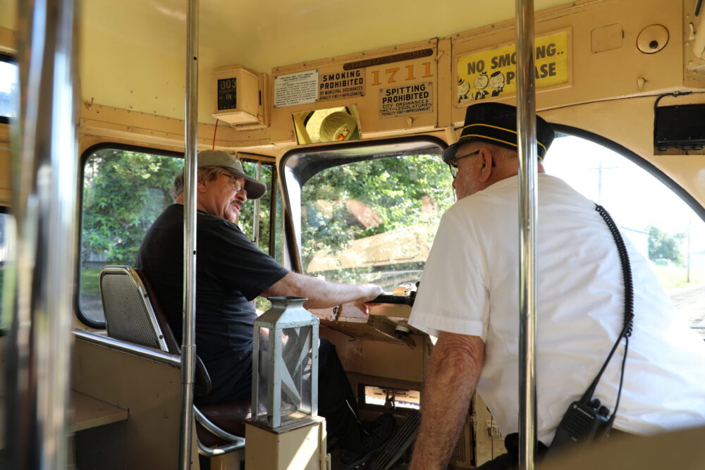 Instructor giving tips to new operator in the seat of PCC streetcar 1711