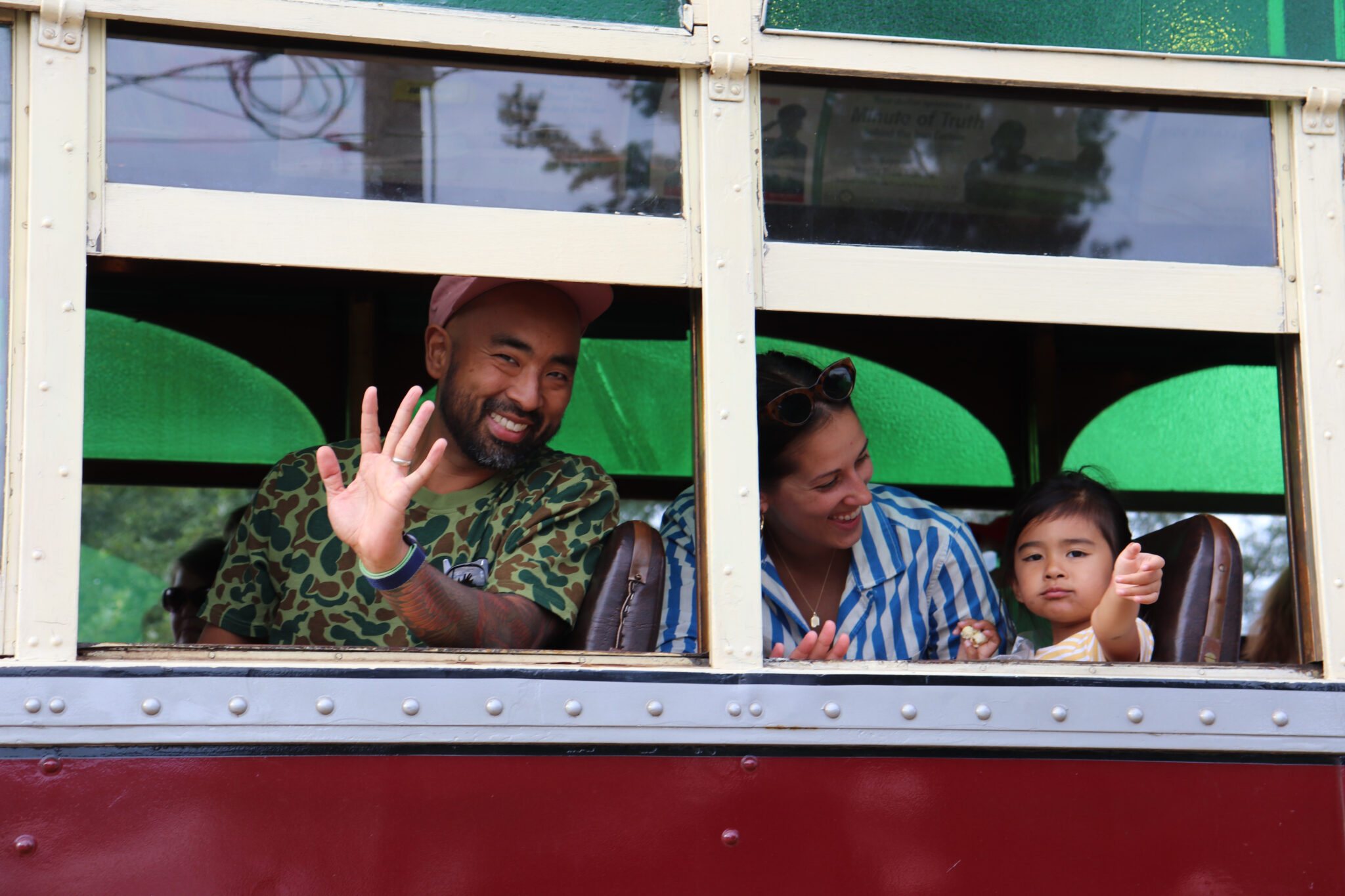 Family waves out trolley window