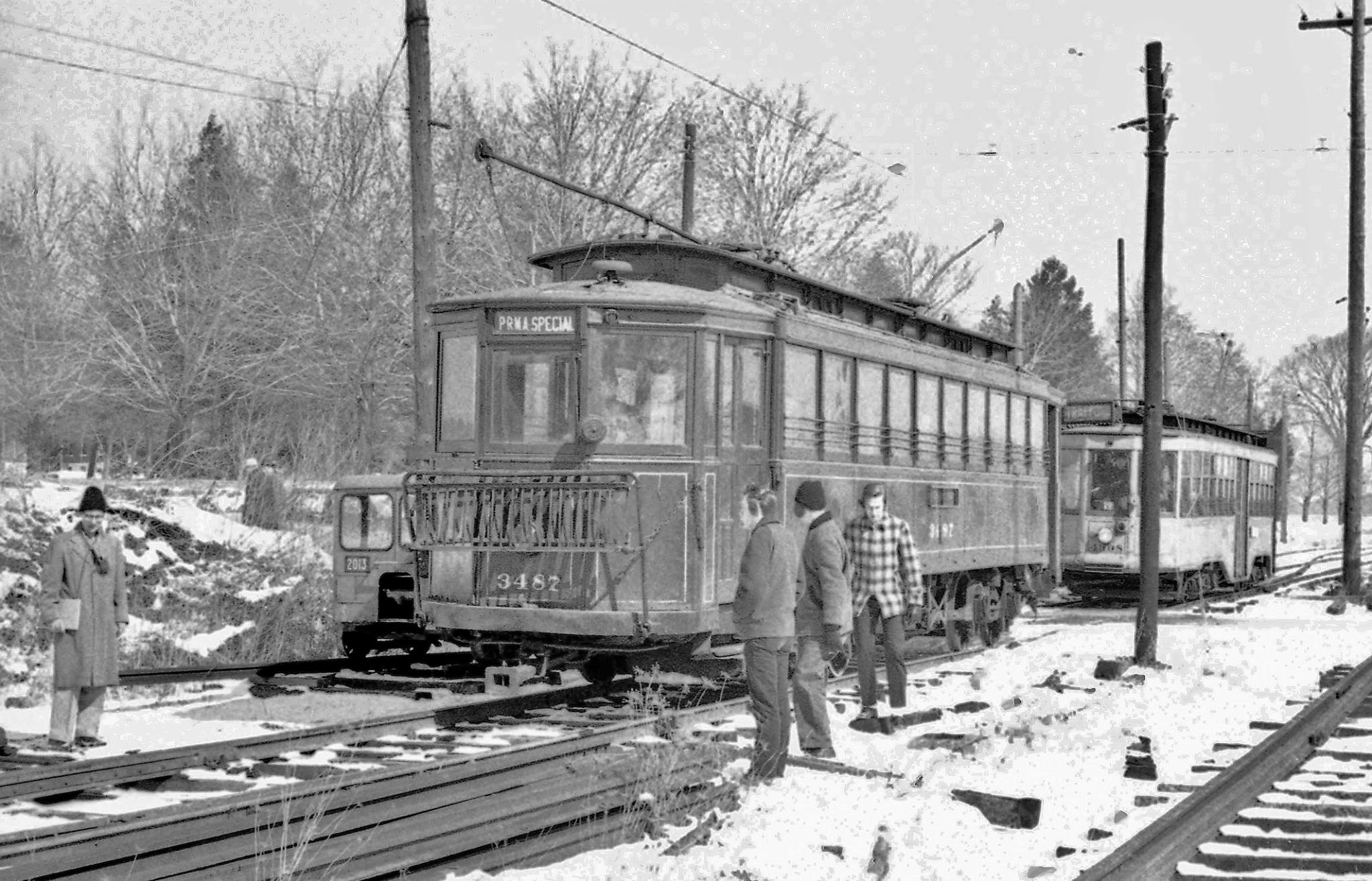 Black and white photo of trolleys arriving a museum in snow